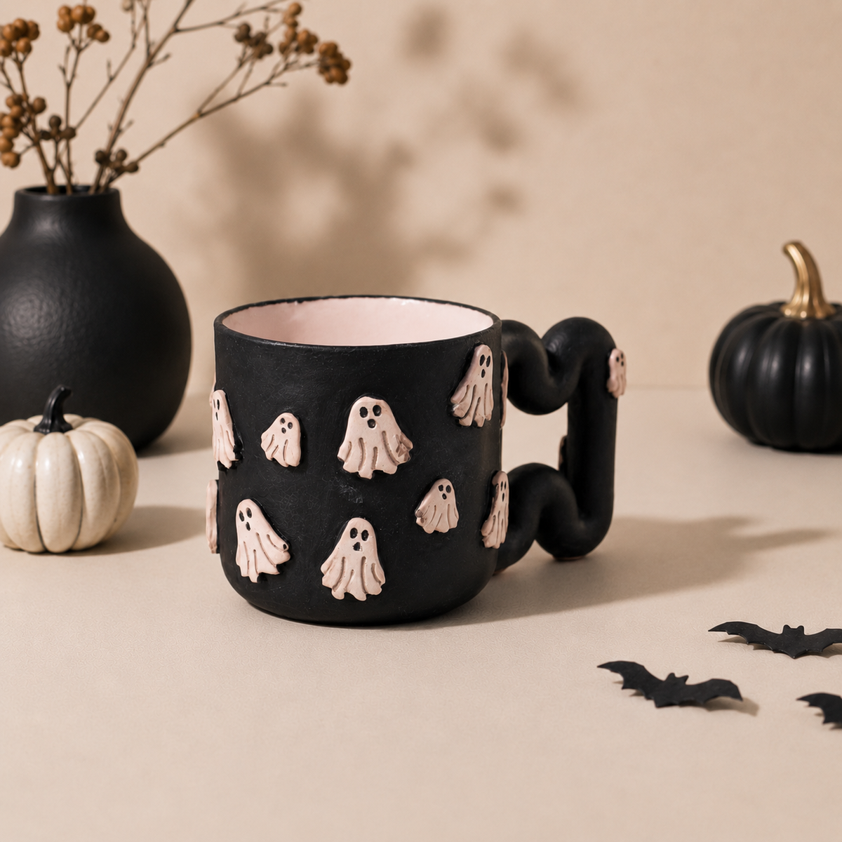 Raised pink ghost appliqués on a black Halloween mug