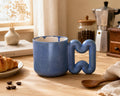 Blue porcelain mug with sculptural wavy handle by HUE Atelier