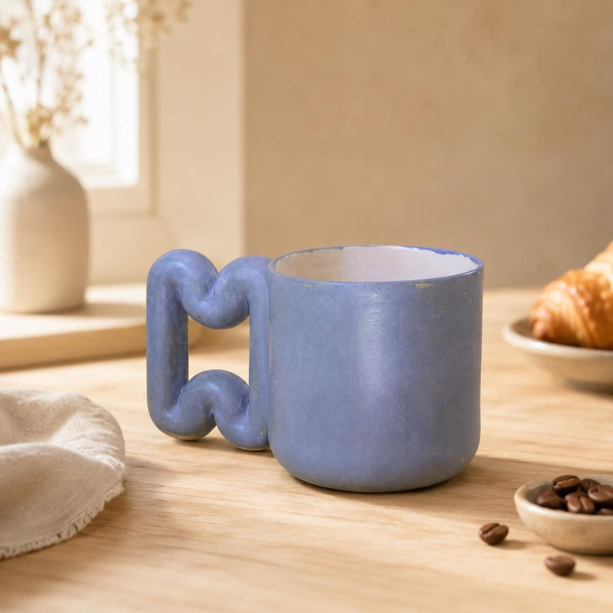 Oversized wavy handle on a blue ceramic cup