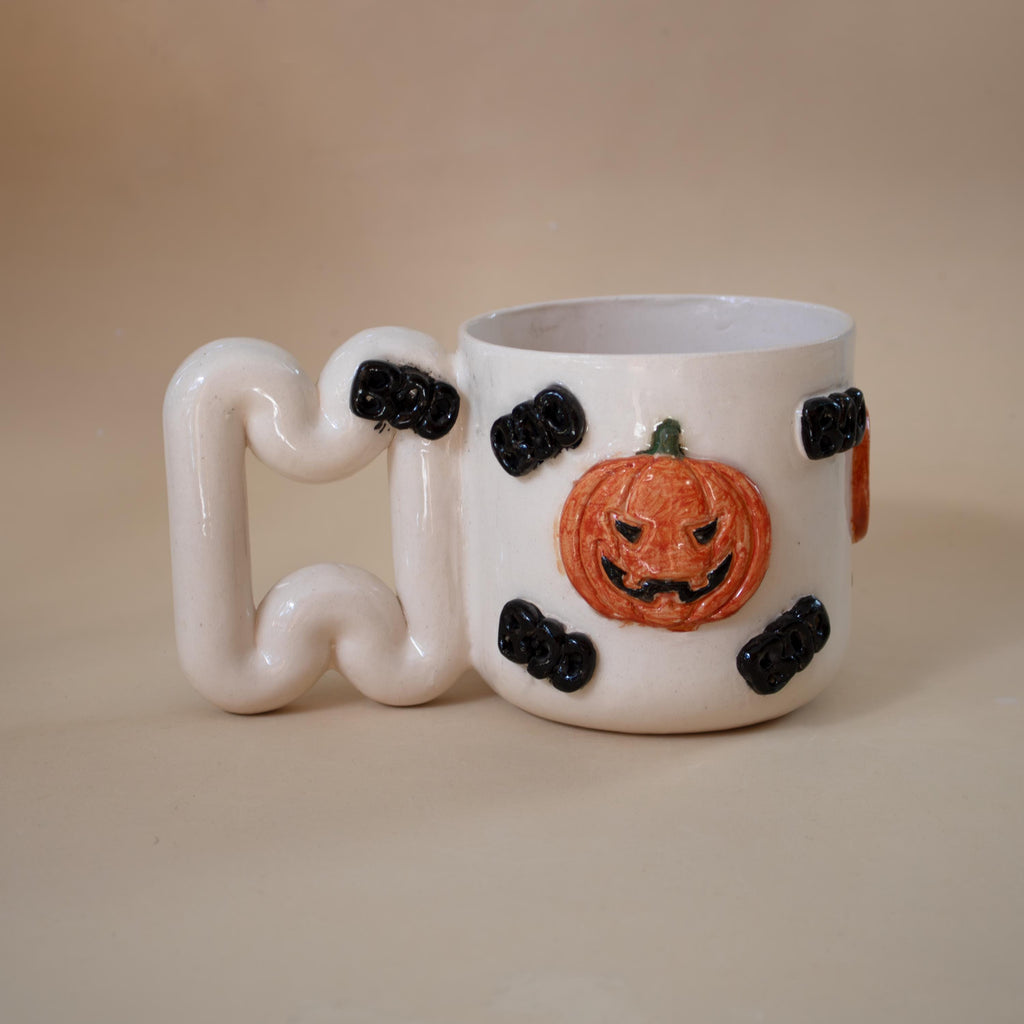 Close look at hand-modelled pumpkins on a ceramic mug