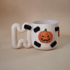 Close look at hand-modelled pumpkins on a ceramic mug