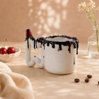 Glossy chocolate glaze dripping over the rim of a white porcelain mug