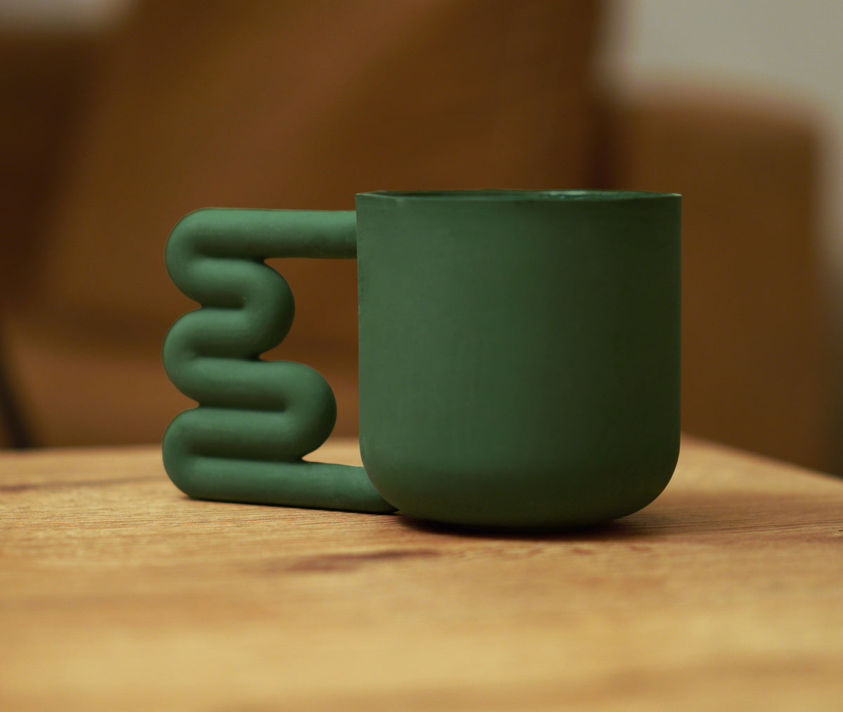 Squiggle handle detail on a green ceramic cup