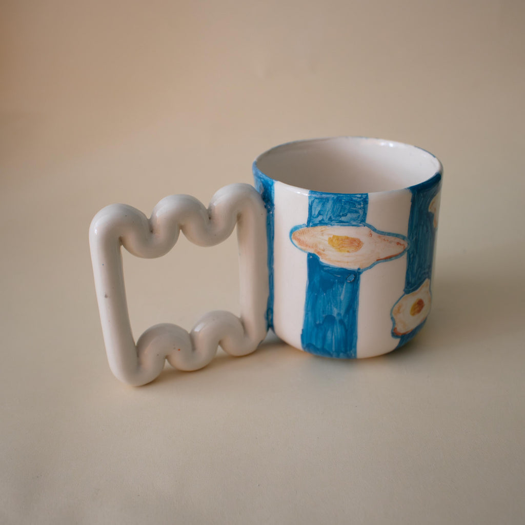 Funky sculptural handle on a striped ceramic cup