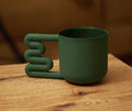 Forest green porcelain mug with stacked wavy handle by HUE Atelier