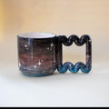 Hand-painted galaxy porcelain mug with funky handle by HUE Atelier