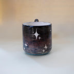 Wavy sculptural handle on a galaxy ceramic cup
