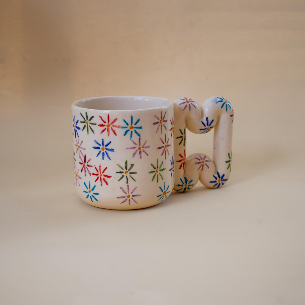 Colourful painted flowers on a glossy coffee mug