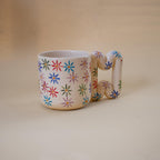 Colourful painted flowers on a glossy coffee mug