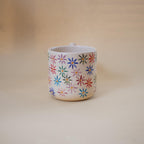 Sculptural funky handle on a floral ceramic cup