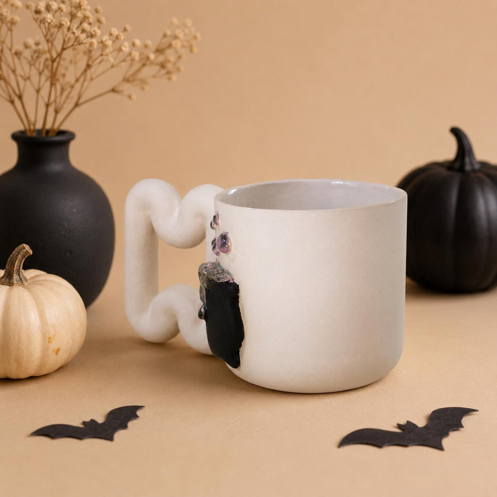 Raised witch hat with red and gold accents on a porcelain Halloween mug