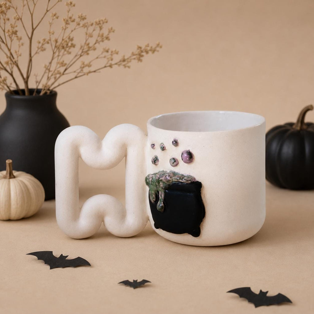 Witch cauldron mug styled in an autumn Halloween coffee corner