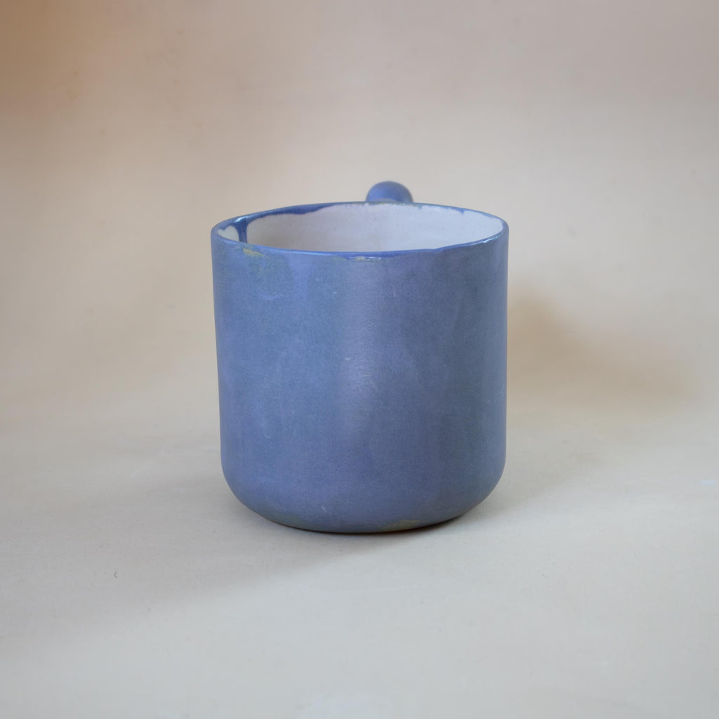 Funky sculptural handle on a dark blue ceramic cup