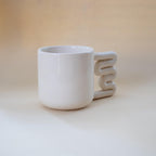 Clean modern coffee mug with sculptural handle