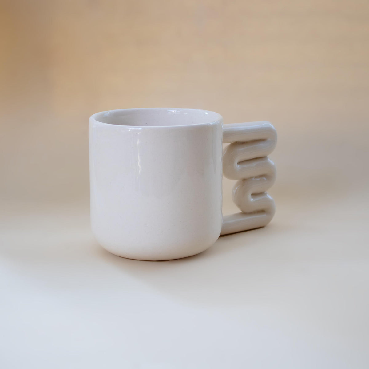 Clean modern coffee mug with sculptural handle