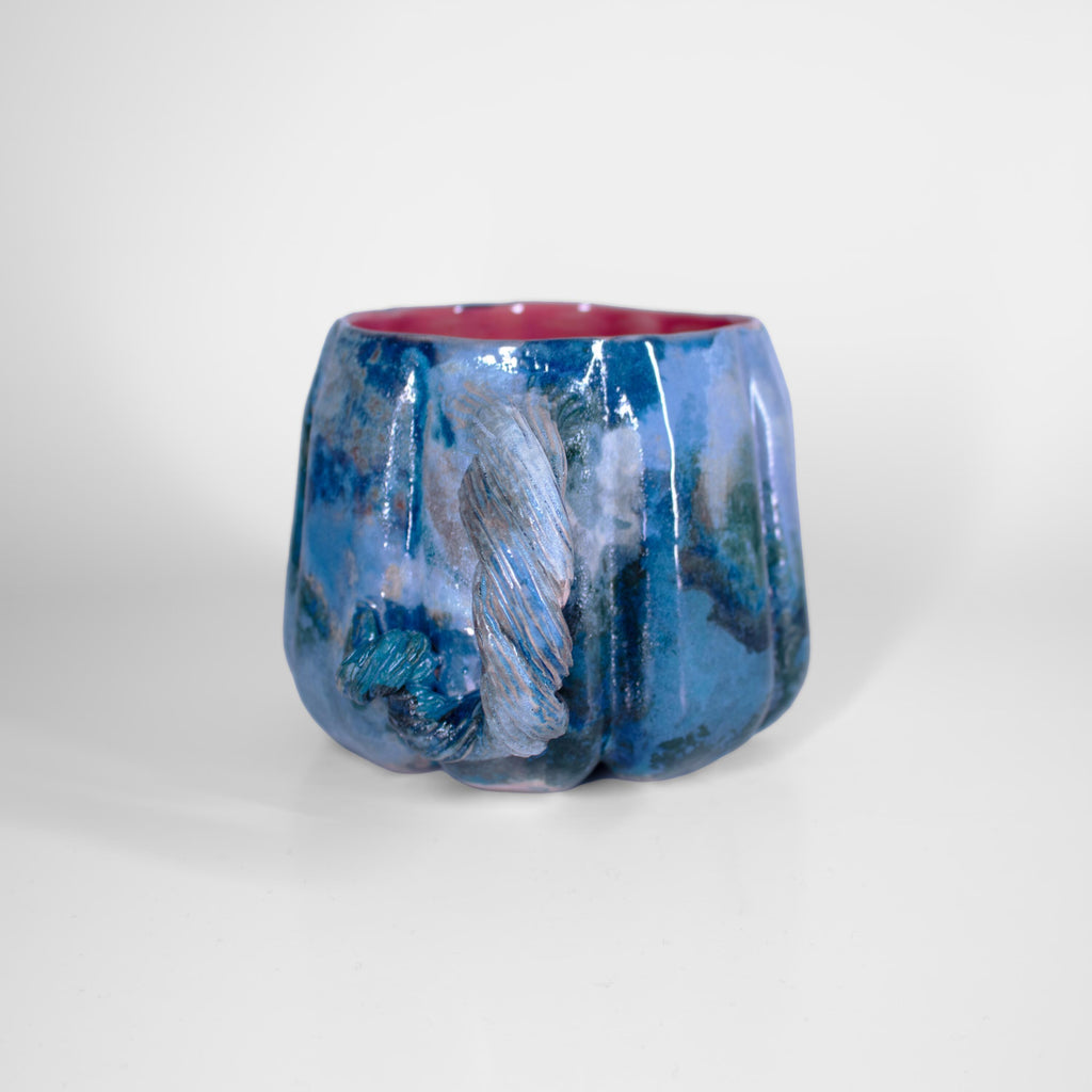 Berry-pink glazed interior of a blue pumpkin mug
