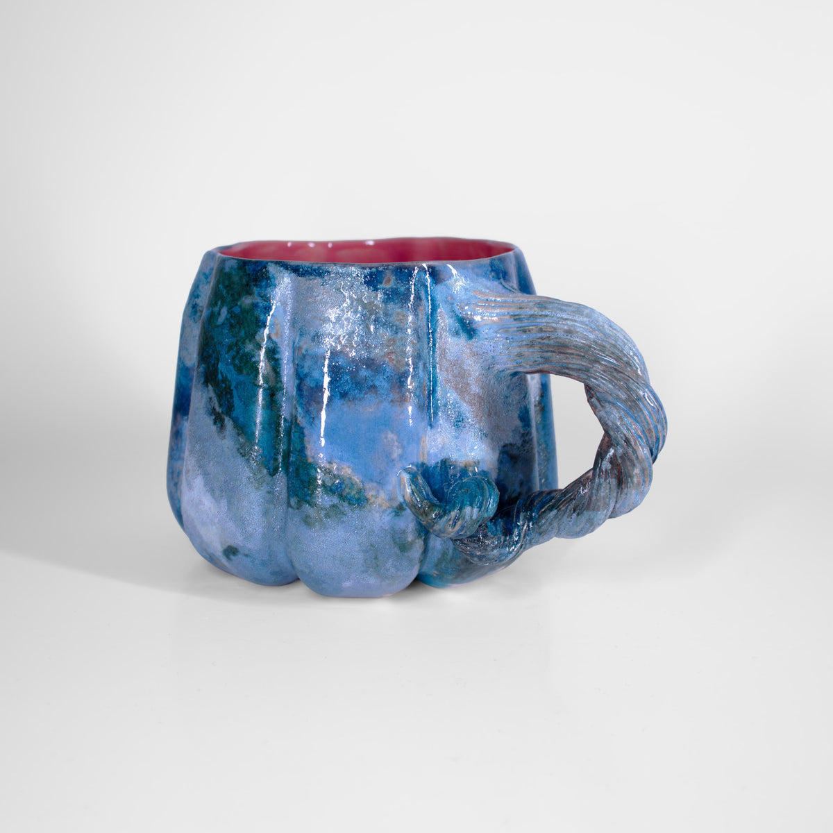 Freehand sculpted vine handle on a stoneware pumpkin cup