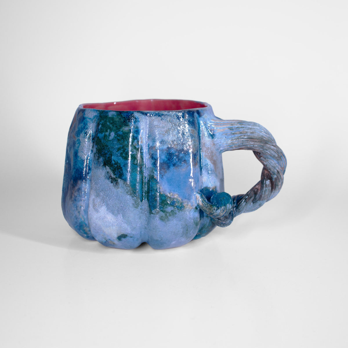 Ribbed pumpkin body with flowing ocean-tone glaze