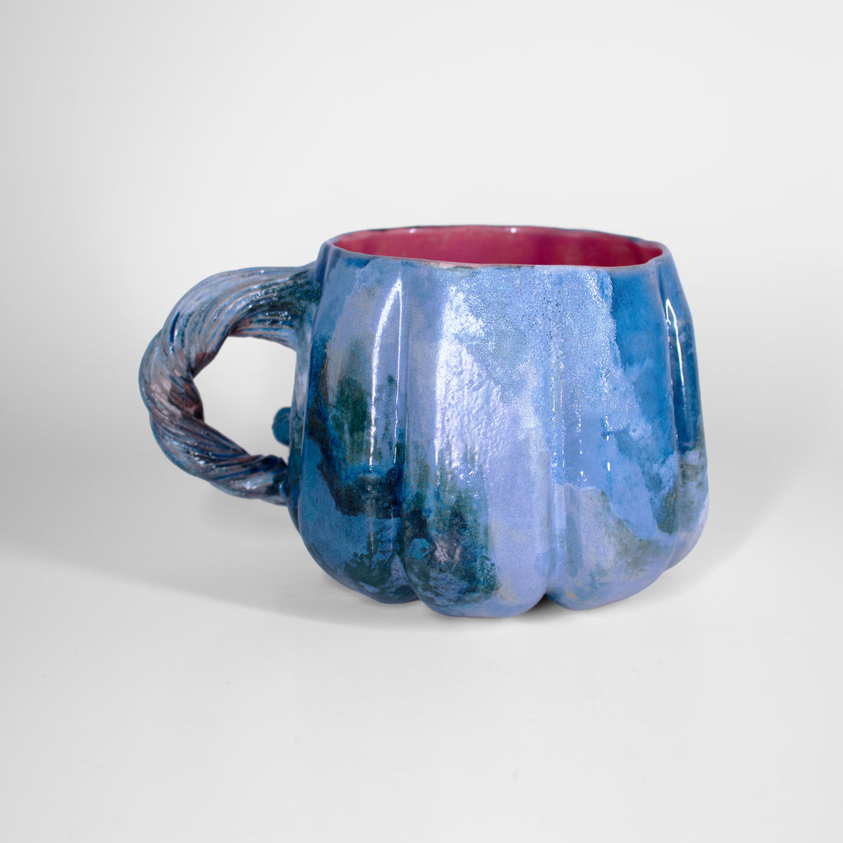 Teal and blue glaze detail on a handmade pumpkin mug