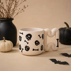 Gothic skull coffee mug in matte white porcelain with glossy black skulls