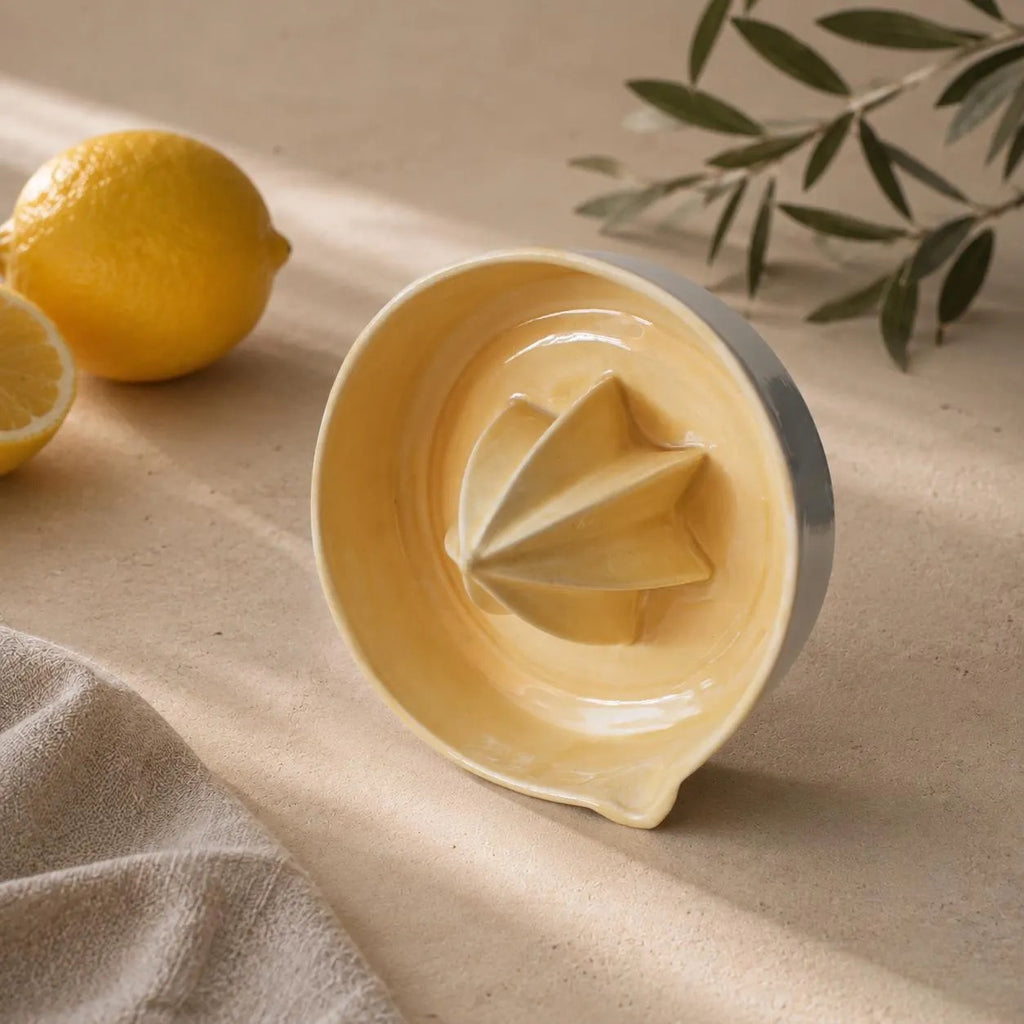 Yellow lemon squeezer with fresh lemons